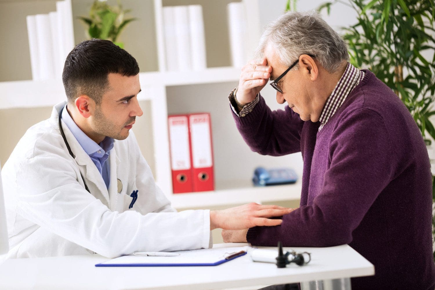 doctor listens to patient explaining headache