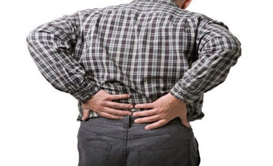 blog picture of a man standing holding his lower back in pain