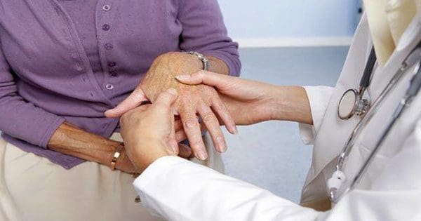 blog picture of older lady at doctors office and doctor is checking her hands