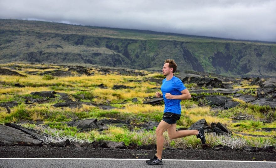 male runner running on mountain road running man jogging fast training