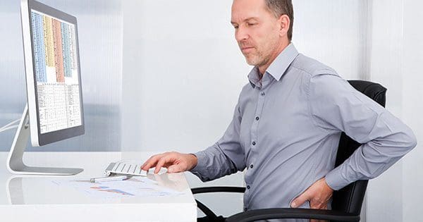 blog picture of man sitting at desk grabbing his back